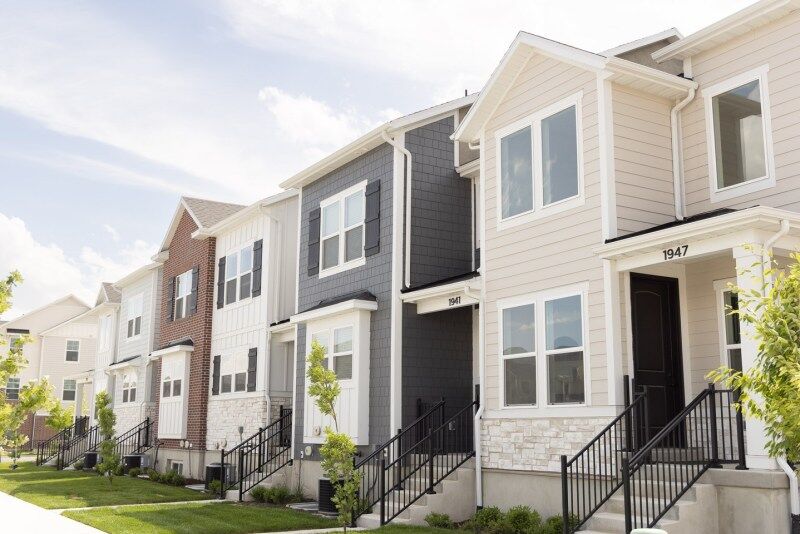 Row of newly built townhomes with varied facades and landscaped front yards