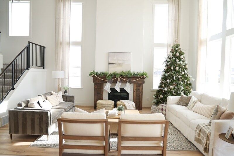 A modern living room with minimal winter decorations, including a Christmas tree