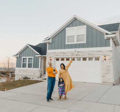 A small family celebrating their first home by popping a drink on their new driveway