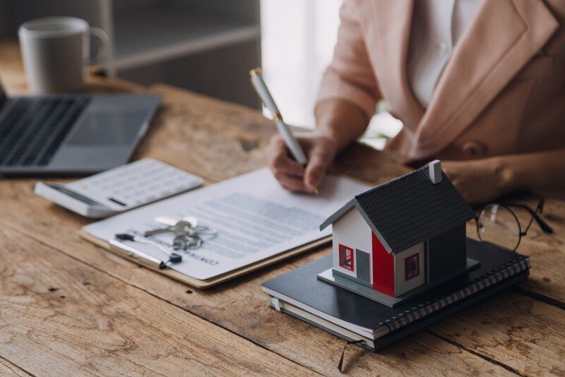 Woman signs a contract to help with financing a new home through preferred lenders