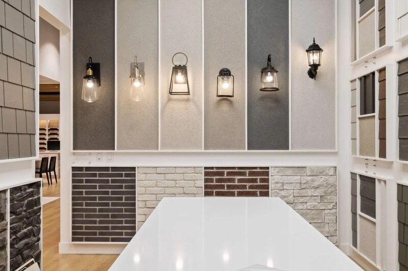 Wall display with exterior light fixtures and brick finish samples, part of the EDGEhomes Design Studio
