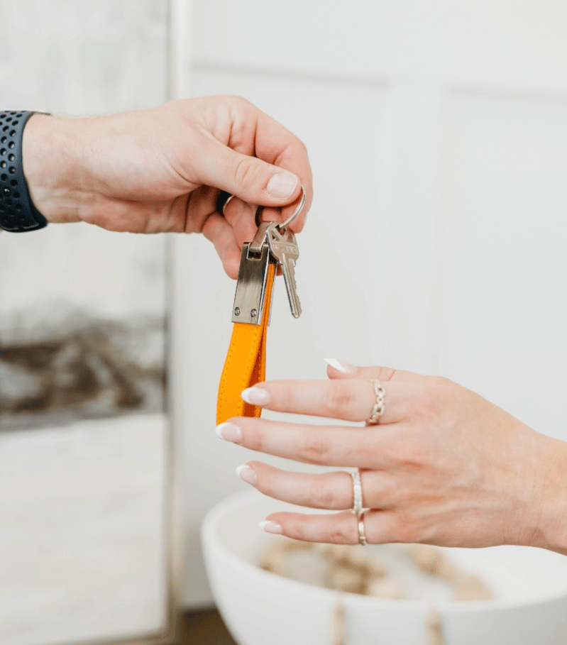 A real estate agent handing over the keys to a new build home to a buyer
